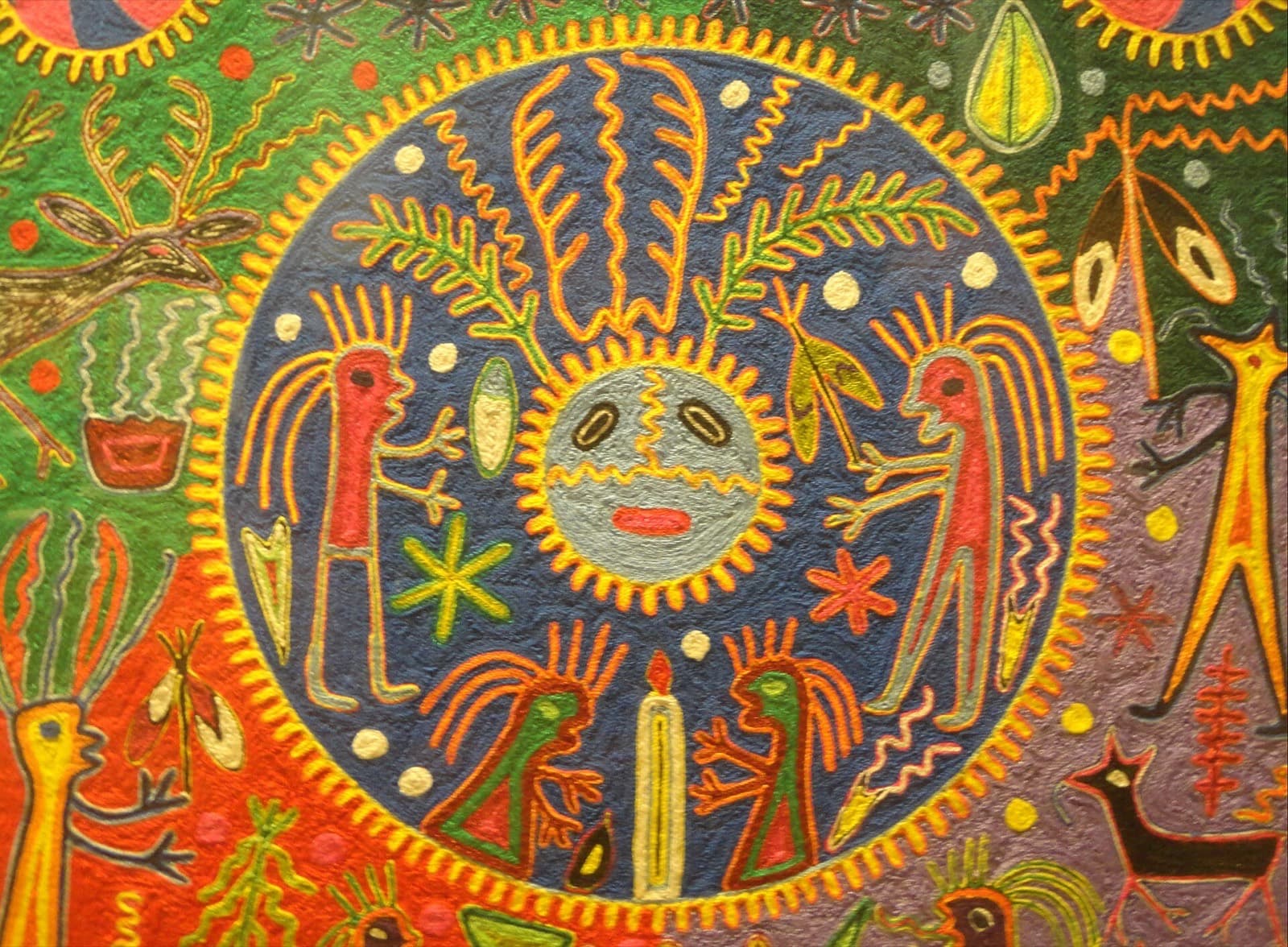 Cuadro de estambre huichol con escena ceremonial de figuras humanas y animales sagrados