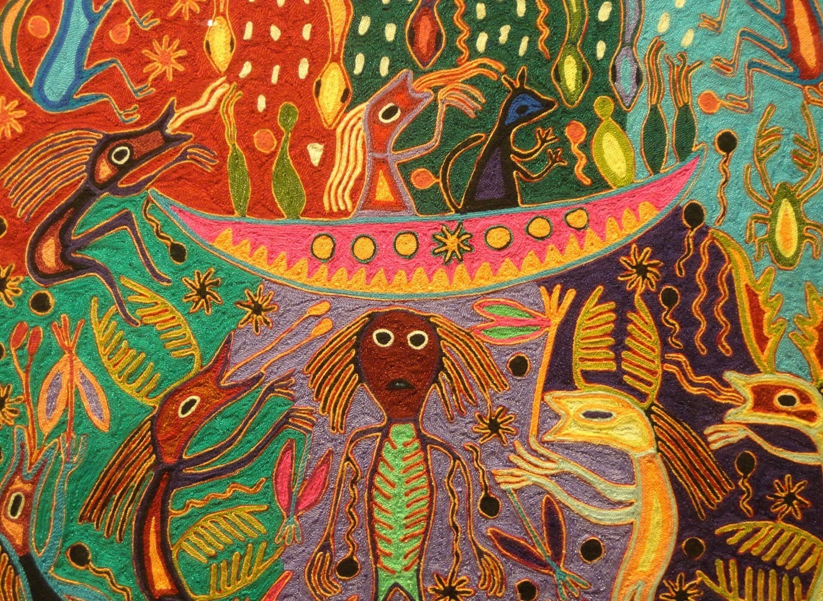 Tabla de estambre huichol con escena mitológica de deidades y animales en colores saturados