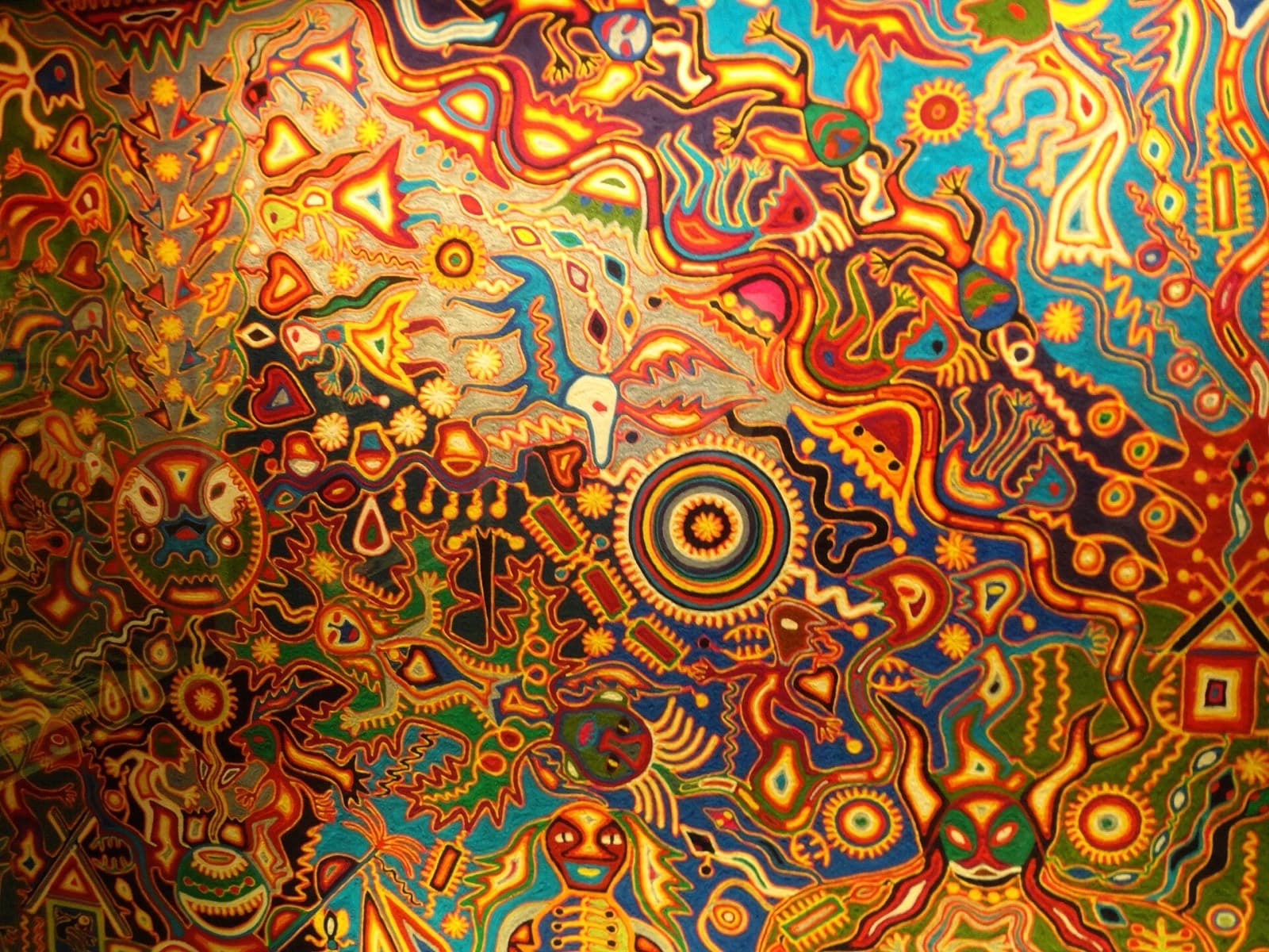 Obra de estambre titulada «La visión de Tatutsi Xuweri Timaiweme», densa composición de figuras y espirales multicolores